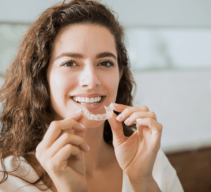 beautiful patient holding retainer Advanced Orthodontics in Kent, WA